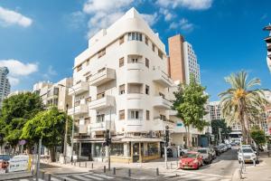 - un bâtiment blanc dans une rue de la ville avec des voitures dans l'établissement Premium 1BD apartment near the beach W/Balcony, à Tel Aviv
