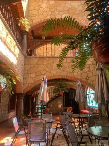 un restaurante con mesas, sillas y sombrillas en Hotel Santa Irene en Cholula