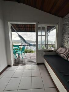 Habitación con cama y balcón con hamaca. en Pousada Vista Grega, en Arraial do Cabo