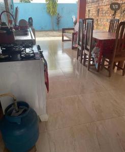 a kitchen with a stove and a table with chairs at Hostel Carol in Boa Vista
