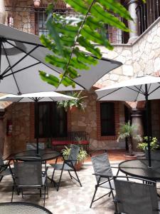 un patio avec des tables, des chaises et des parasols dans l'établissement Hotel Santa Irene, à Cholula