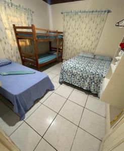 a bedroom with two beds and a staircase in it at Hostel Carol in Boa Vista