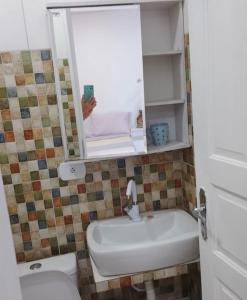 y baño con lavabo, aseo y espejo. en Hostel Carol en Boa Vista