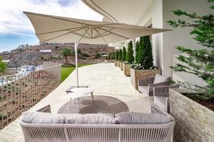 un patio con mesa y sombrilla en TVB211 - Luxury Mountain resort, by roomservices, en Benahavís