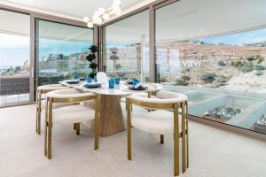 comedor con mesa, sillas y ventanas grandes en TVB211 - Luxury Mountain resort, by roomservices, en Benahavís