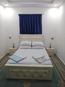 a bedroom with a large bed with a blue window at Your House For Family in Agadir
