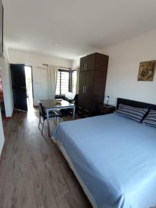 1 dormitorio con 1 cama grande y 1 mesa en Abeli Aparts en San José