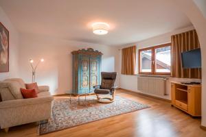 a living room with a couch and a chair at Ferienwohnung Böck in Kiefersfelden