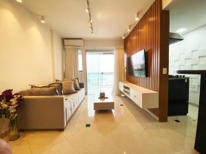 a living room with a couch and a television at 30 secs to the beach, 3 balconies, 2 bdrms ensuite in Rio de Janeiro