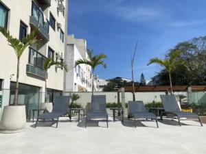 a group of chairs and tables in front of a building at 30 secs to the beach, 3 balconies, 2 bdrms ensuite in Rio de Janeiro