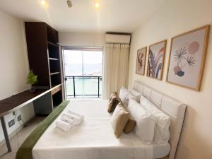 a large white bed in a room with a window at 30 secs to the beach, 3 balconies, 2 bdrms ensuite in Rio de Janeiro