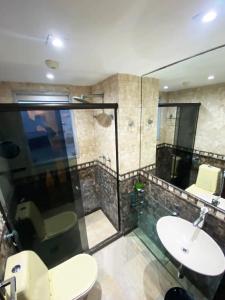 a bathroom with a toilet and a sink and a shower at 30 secs to the beach, 3 balconies, 2 bdrms ensuite in Rio de Janeiro