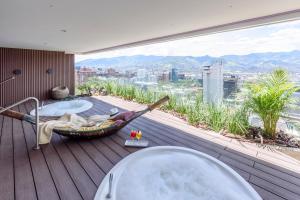 a bathroom with a tub and a hammock on a deck at Diez Hotel Categoría Colombia in Medellín
