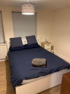 1 dormitorio con 1 cama grande con manta azul en Large Luxury appartment, en Cobham