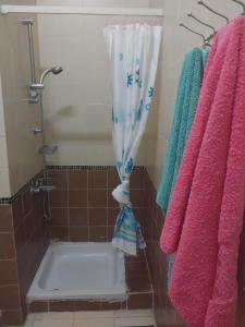 a bathroom with a shower with a tub and towels at jenylyn`s chalet` families only` in Ain Sokhna
