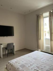a bedroom with a bed and a desk and a television at La Piazzetta Anzio in Anzio