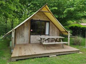 Cabaña de madera pequeña con mesa de picnic y banco en Camping le Rouge Gorge **** 10' Puy du Fou, en Saint-Laurent-sur-Sèvre
