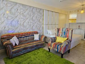 a living room with two chairs and a couch at Airport Studio Apartments-JKIA in Nairobi
