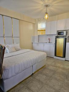 a kitchen with a large white bed in a room at Airport Studio Apartments-JKIA in Nairobi