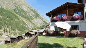 a house with flowers on the balconies and a mountain at Chalet Michelangelo in Zermatt