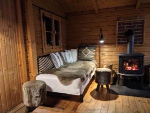 a bedroom with a bed and a fireplace in a cabin at Blockhütte 35 km nördlich von Hamburg in Langeln