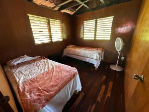 a room with two beds and a fan in it at Cabaña a la orilla de la laguna in Bacalar