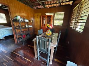 a dining room with a table and a room with a bed at Cabaña a la orilla de la laguna in Bacalar