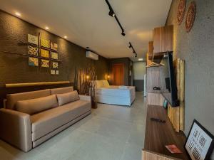 - un salon avec un canapé et un lit dans l'établissement Gamboa Patacho Apto 002 Bloco B - ER Hospedagens, à Porto de Pedras