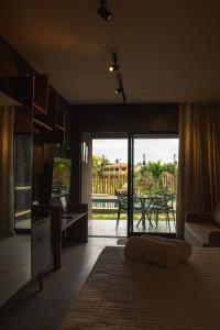 - une chambre avec un lit et une vue sur une terrasse dans l'établissement Gamboa Patacho Apto 002 Bloco B - ER Hospedagens, à Porto de Pedras
