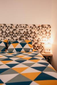 um quarto com uma cama com um edredão colorido em Appartement de Thomas em Charleville-Mézières