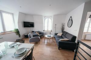 uma sala de estar com um sofá e uma mesa em Appartement de Thomas em Charleville-Mézières