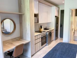 a small kitchen with white cabinets and a mirror at Zimbali Lakes Boulevard Suites 220 in Ballito