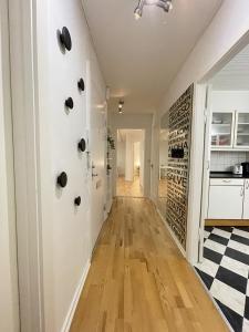 Il dispose d'une cuisine et d'un couloir avec des murs blancs et du parquet. dans l'établissement aday - Large terrace and 2 bedrooms apartment in the heart of Randers, à Randers