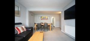 a living room with a black couch and a table at Chessington Blue with parking in Chessington