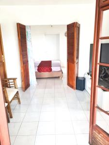 a room with a bed and a white tiled floor at Maison spacieuse à Saint-Joseph avec vue sur la mer in Saint-Joseph