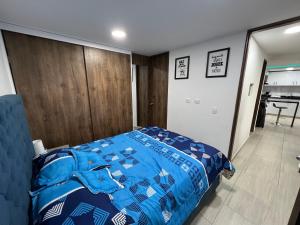 een slaapkamer met een blauw dekbed op een bed bij Apartamento nuevo en Barranquilla in Barranquilla