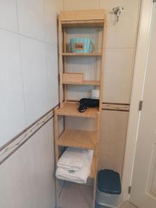 uma estante de livros de madeira na casa de banho com toalhas em Casa Karavola in Galanado village-Naxos em Galanádhon