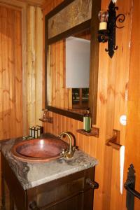 y baño con lavabo y pared de madera. en Complejo Rural Puerto Peñas, en Aroche