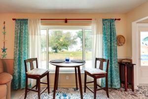 een tafel en stoelen in een kamer met een raam bij Waterfront Treasure Coast Home with Pool and Lanai! in Fort Pierce