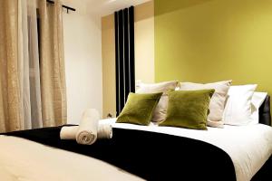 una camera da letto con un letto con cuscini verdi di Garden Eleven - Duplex City Centre Apartment a Hemel Hempstead