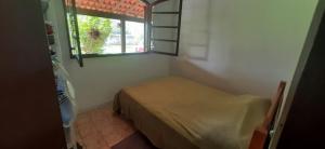 een kleine slaapkamer met een bed en een raam bij Sítio Vivendo & Aprendendo in Tanguá
