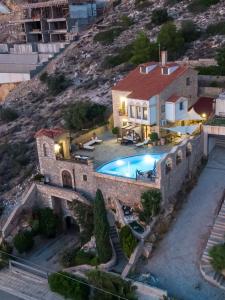a house with a swimming pool in front of a mountain at Four Seasons Stonework Castle in Lagonissi