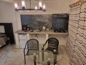 une cuisine avec une table en verre et deux chaises dans l'établissement Depa para 2 personas con aire acondicionado, à Manzanillo