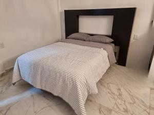 - un lit avec une couverture noire et blanche dans l'établissement Depa para 2 personas con aire acondicionado, à Manzanillo