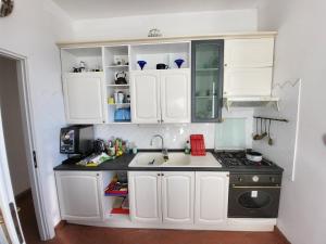 a small kitchen with white cabinets and a sink at Monterosso Servano's Villas in Monterosso al Mare