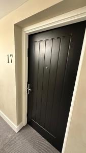 a black door in the corner of a room at Modern & stylish 1 bedroom flat in London