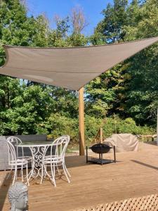 a canopy over a table and chairs on a wooden deck at Open Sky Glamping Kawartha Dome in Marmora