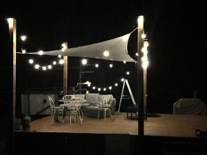 a patio with a table and chairs at night at Open Sky Glamping Kawartha Dome in Marmora