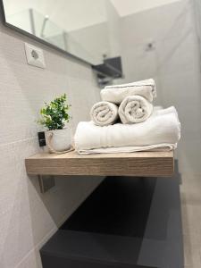 un mucchio di asciugamani su una mensola in bagno di La Piazzetta Anzio ad Anzio