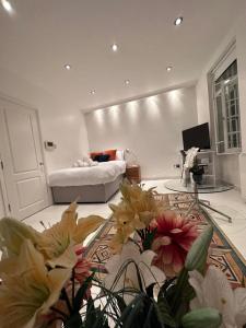 Smithfield St Paul Farringdon Central London Apartment في لندن: غرفة نوم بسرير وغرفة بها ورد